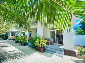 A covered outdoor area with a seating arrangement and potted plants. - Balungiboutiquehotel (Uroa)