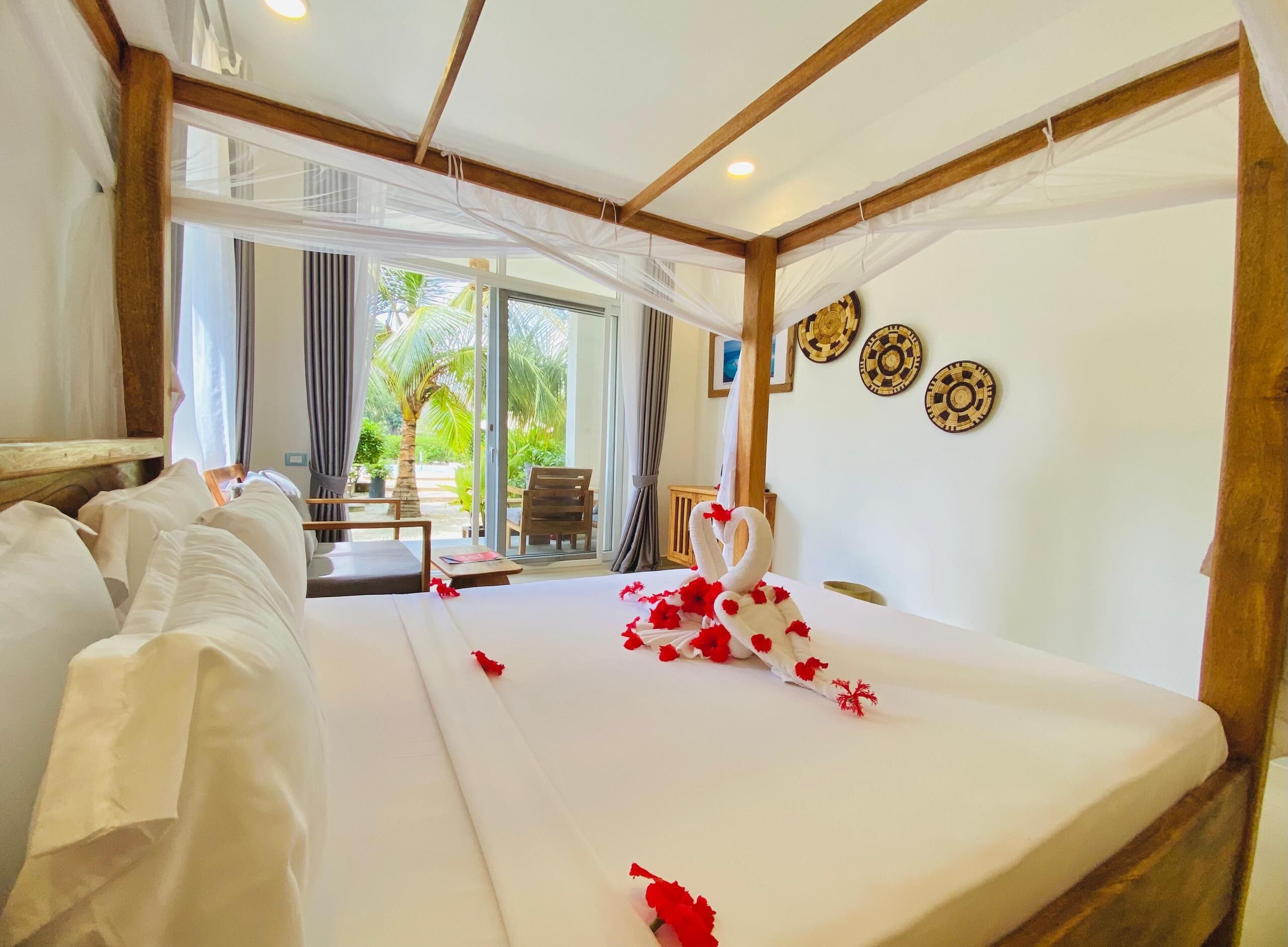 Habitación de hotel con cama, vistas al exterior y decoración en la pared.