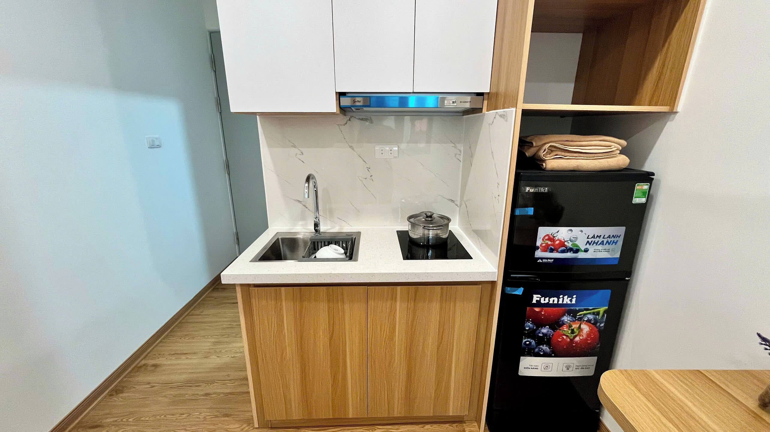 A compact kitchen with a sink, a stove, and a refrigerator.