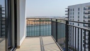 Un balcón con vista a un río y edificios a lo lejos.