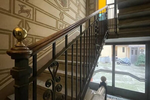Una escalera con barandillas ornamentales y pasamanos, que conduce a un piso superior.