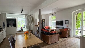 Un espace de vie moderne comprenant un coin repas, un espace détente et un téléviseur.