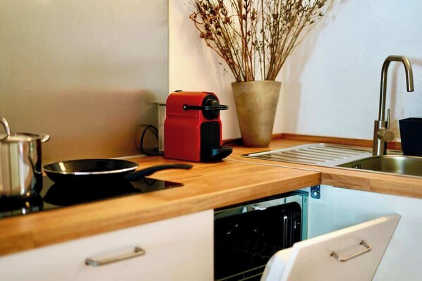 Eine Küche mit einem Toaster, einer Pfanne, einem Spülbecken und einer Topfpflanze.