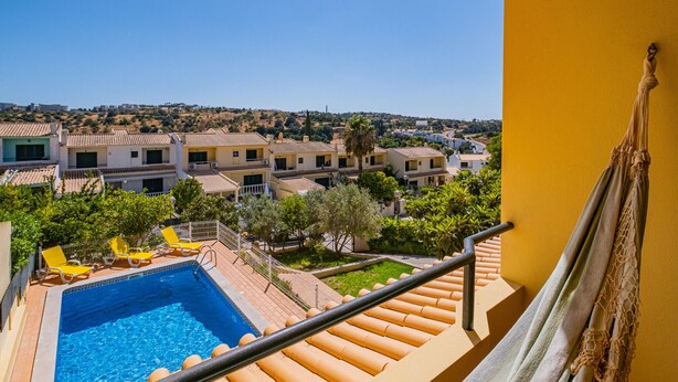 A pool area with a clear view of the surrounding buildings and landscape. - Villa Caliços By Dreamplaces (Albufeira)