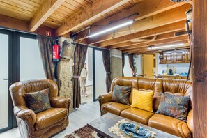 A cozy living room with leather sofas, a coffee table, and a fireplace.