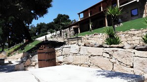 A stone retaining wall, a wooden gate, and a building with a balcony.