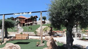 A house with a red roof, a swing set, and a stone pathway.