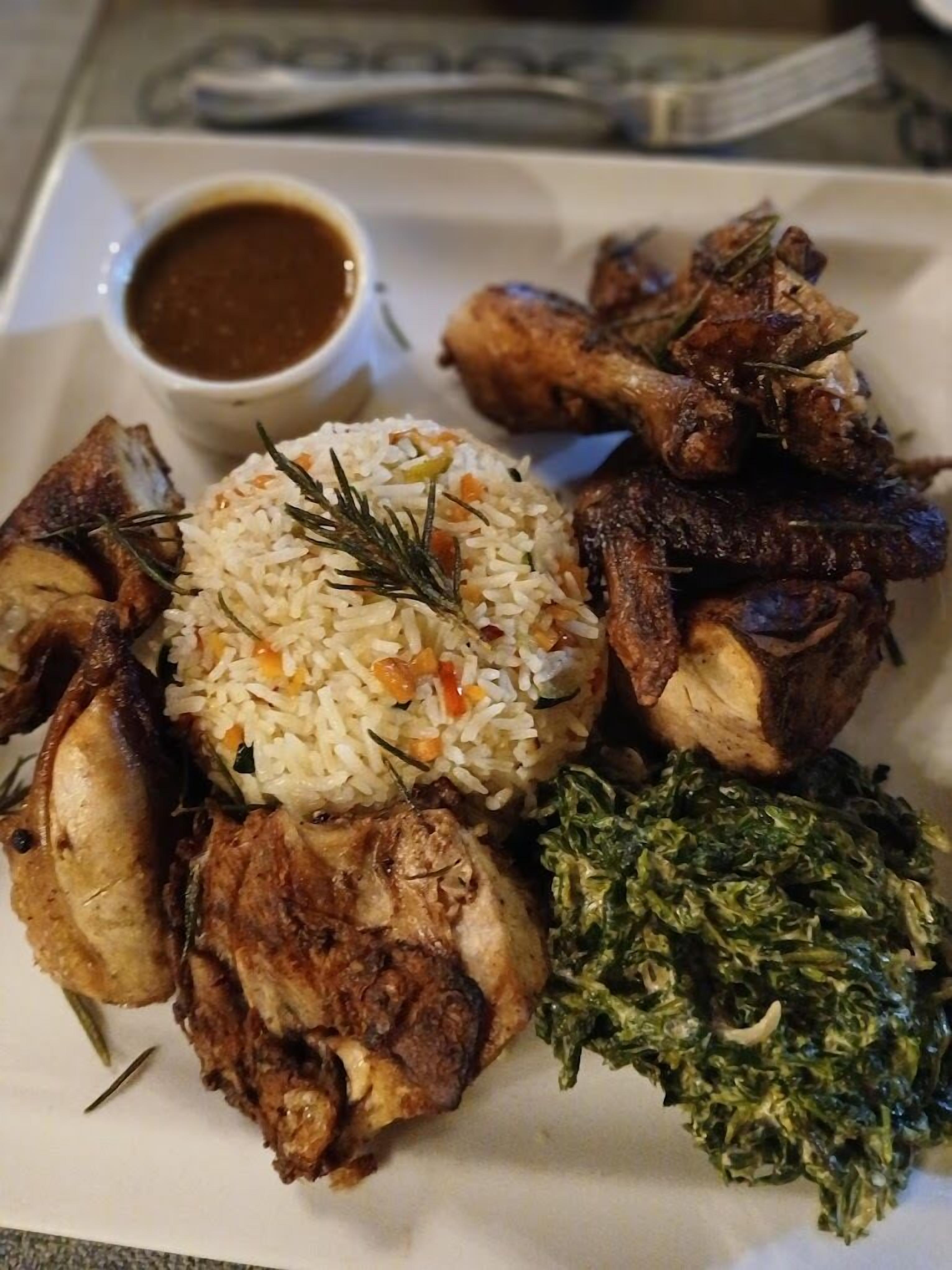 A plate of food including rice, meat, and greens.