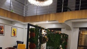 A modern lobby with a seating area, a decorative wall with plants, and a chandelier. - Enkipai Hill Hotel (Narok)