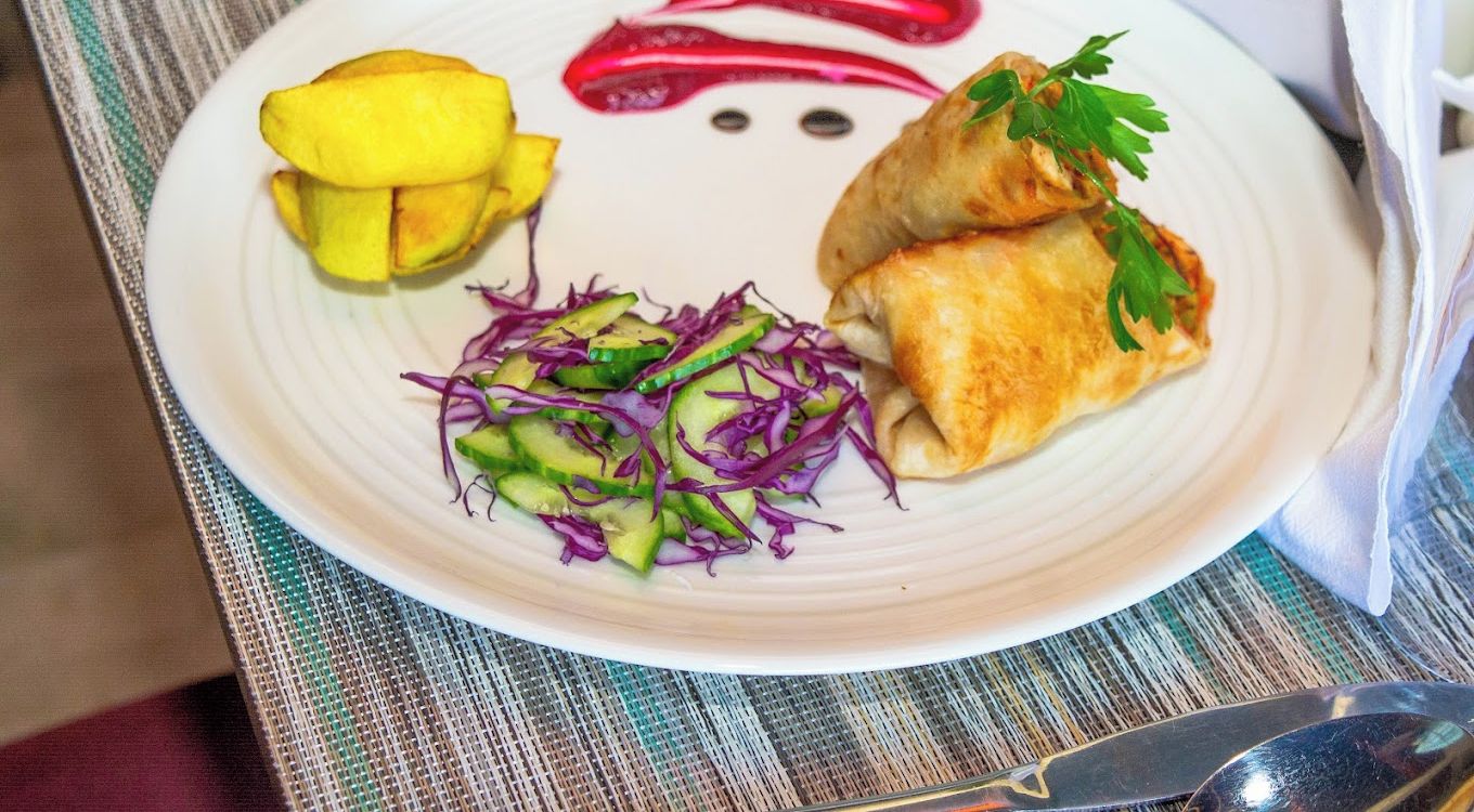 Prato com comida, incluindo pães, fatias de manga e uma salada.