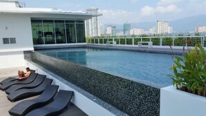 A rooftop pool with lounge chairs and a cityscape view. - Urbano Luxury Homestay (George Town)