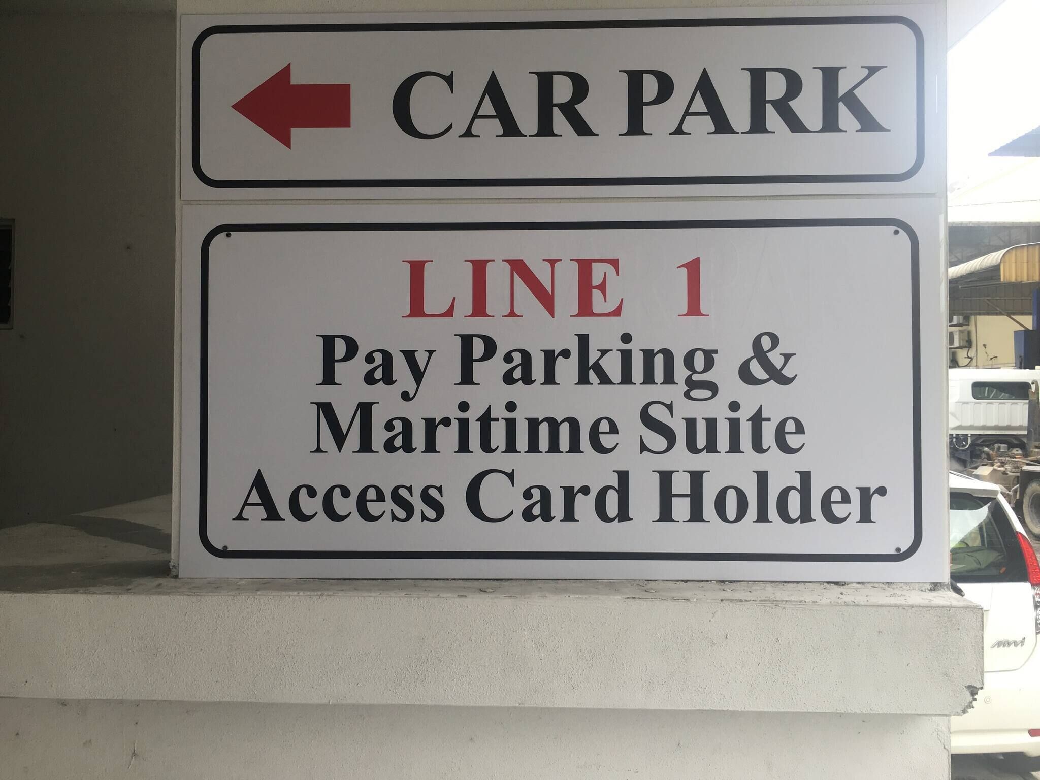 A sign indicating a car park with an arrow pointing to the left.