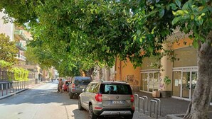 A street lined with parked cars and trees, with buildings on either side. - FLORENTINE'S HOUSE  (Catania)