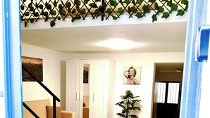 A living room with a sofa, a coffee table, a potted plant, and a staircase. - FLORENTINE'S HOUSE  (Catania)