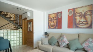 A modern living room with a sofa, coffee table, and artwork on the wall. - GC Adosado Telde (Telde)