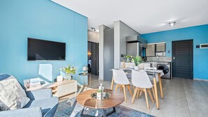 Ein modernes Wohnzimmer mit Sofa, Couchtisch und Essbereich.