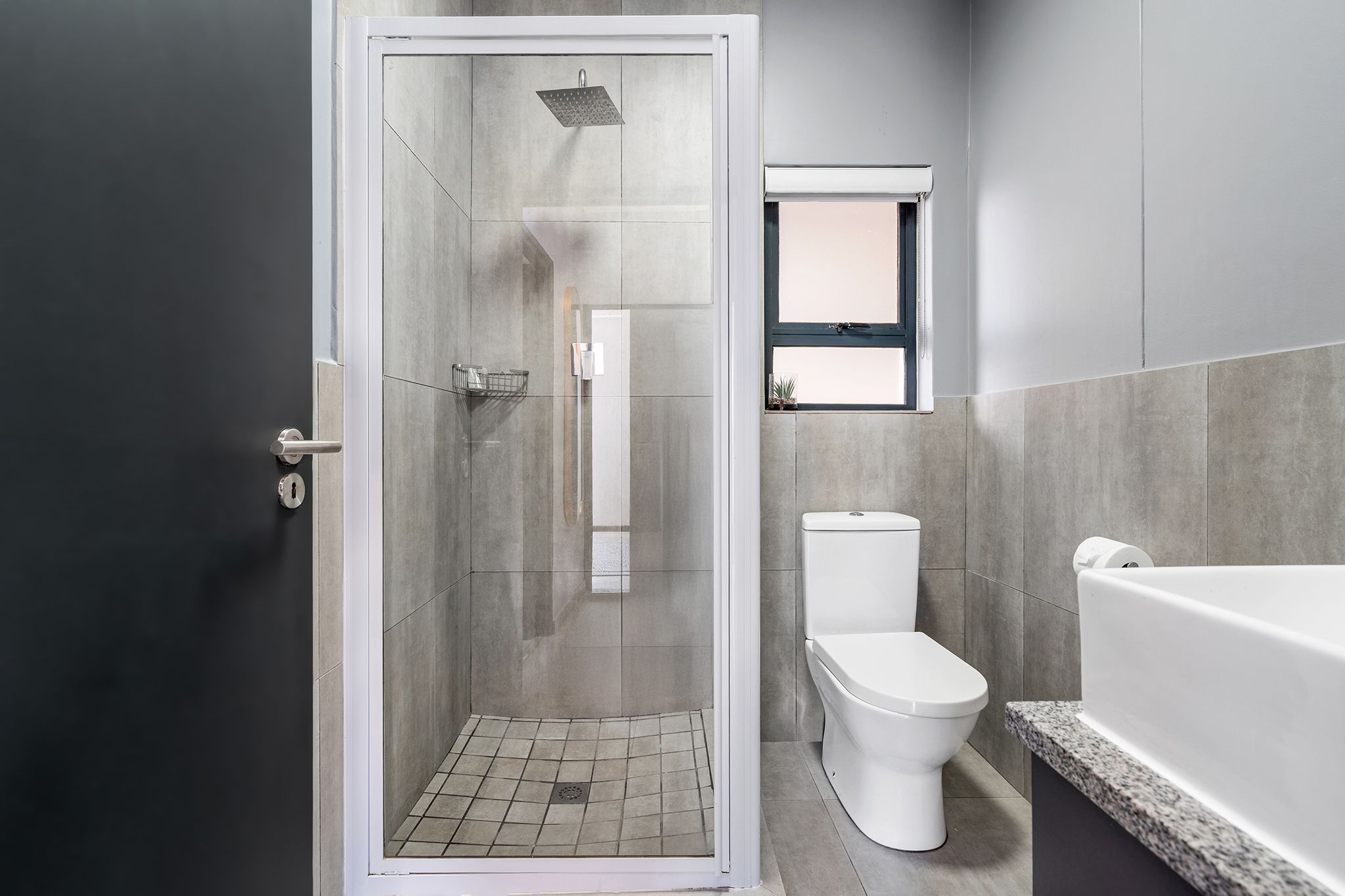 Ein modernes Badezimmer mit einer Duschkabine, einer Toilette und einer Badewanne.