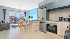 Eine moderne Küche mit Kühlschrank, Backofen und Kaffeemaschine.