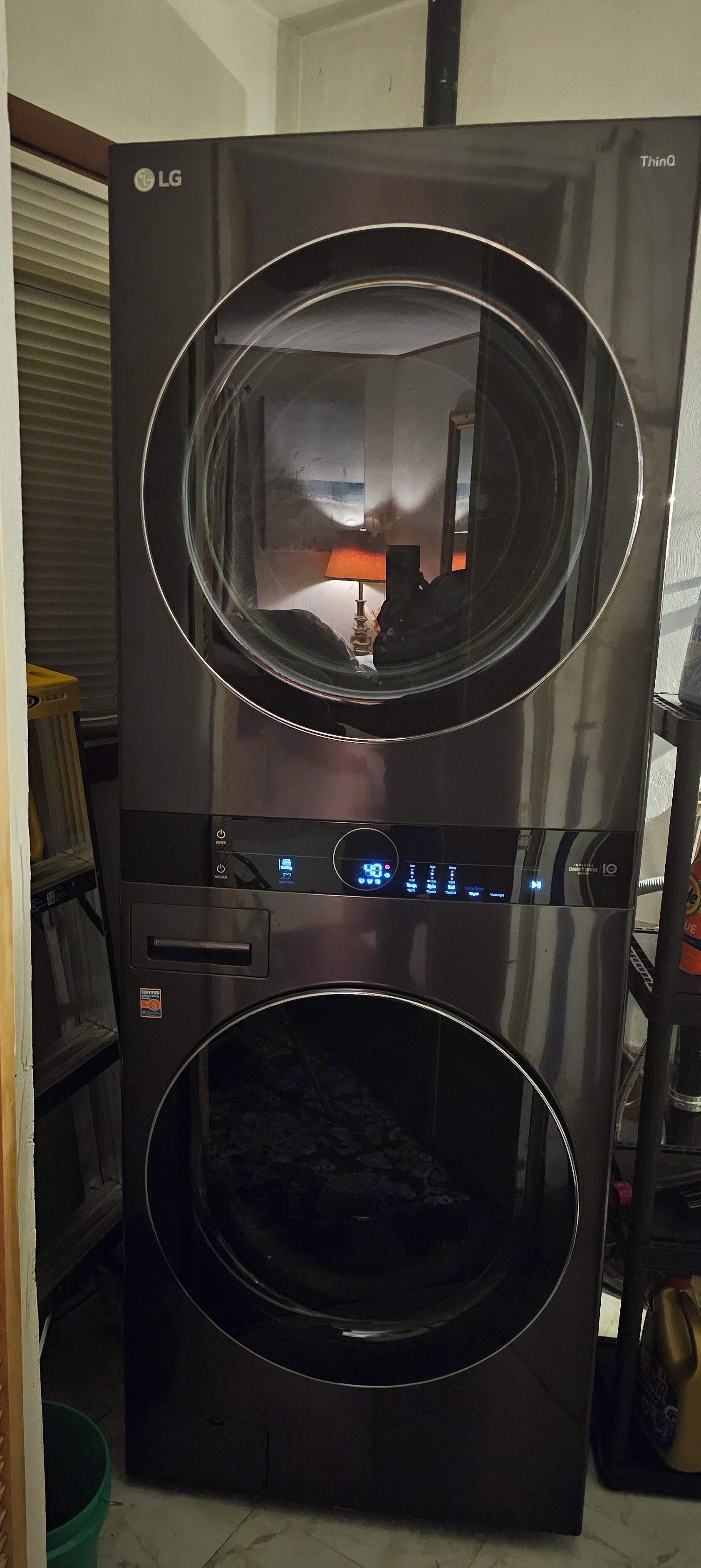A black LG refrigerator with a digital display, two door compartments, and a water dispenser.