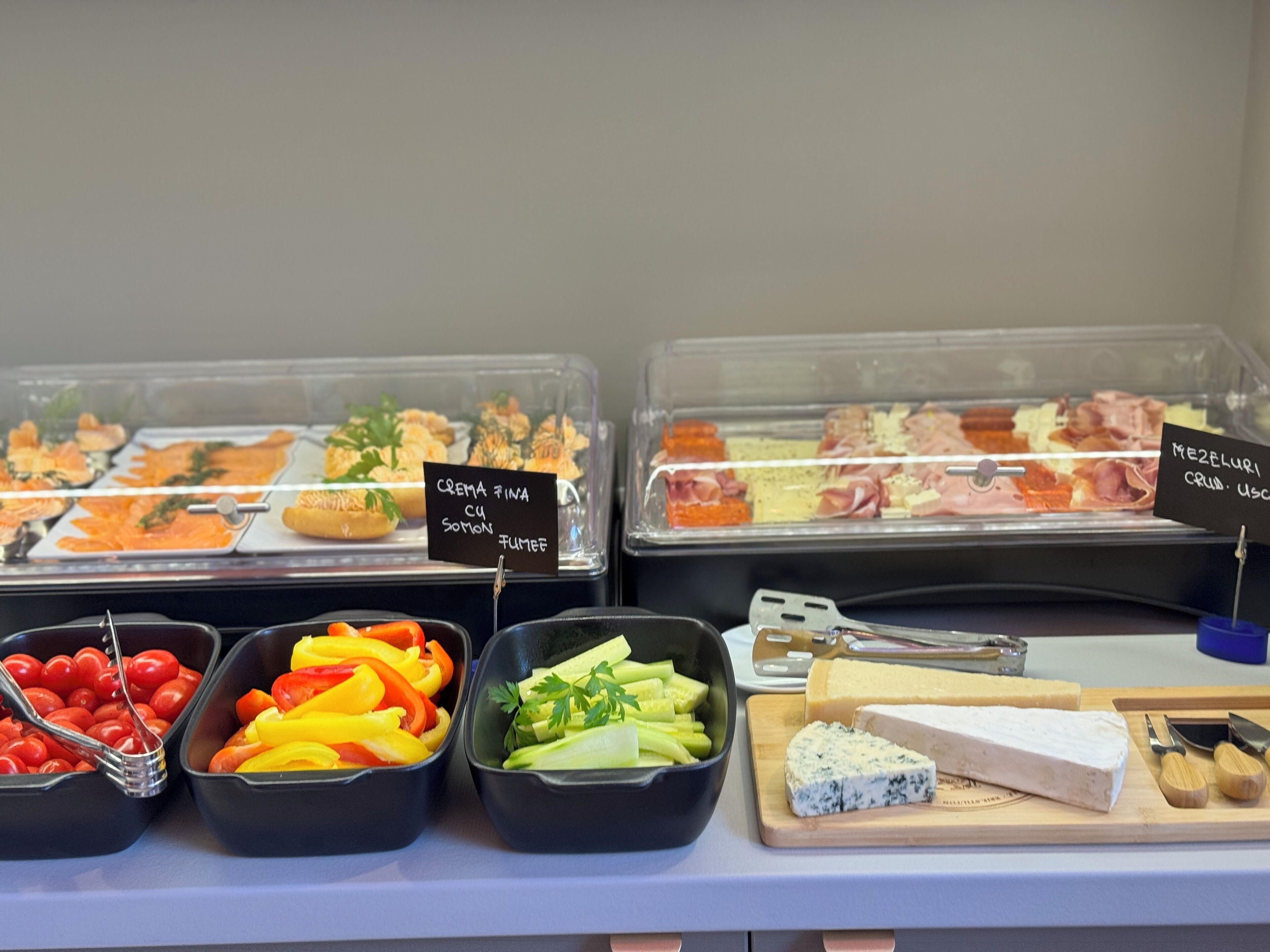 A buffet with various food items including cheese, fruits, and vegetables.