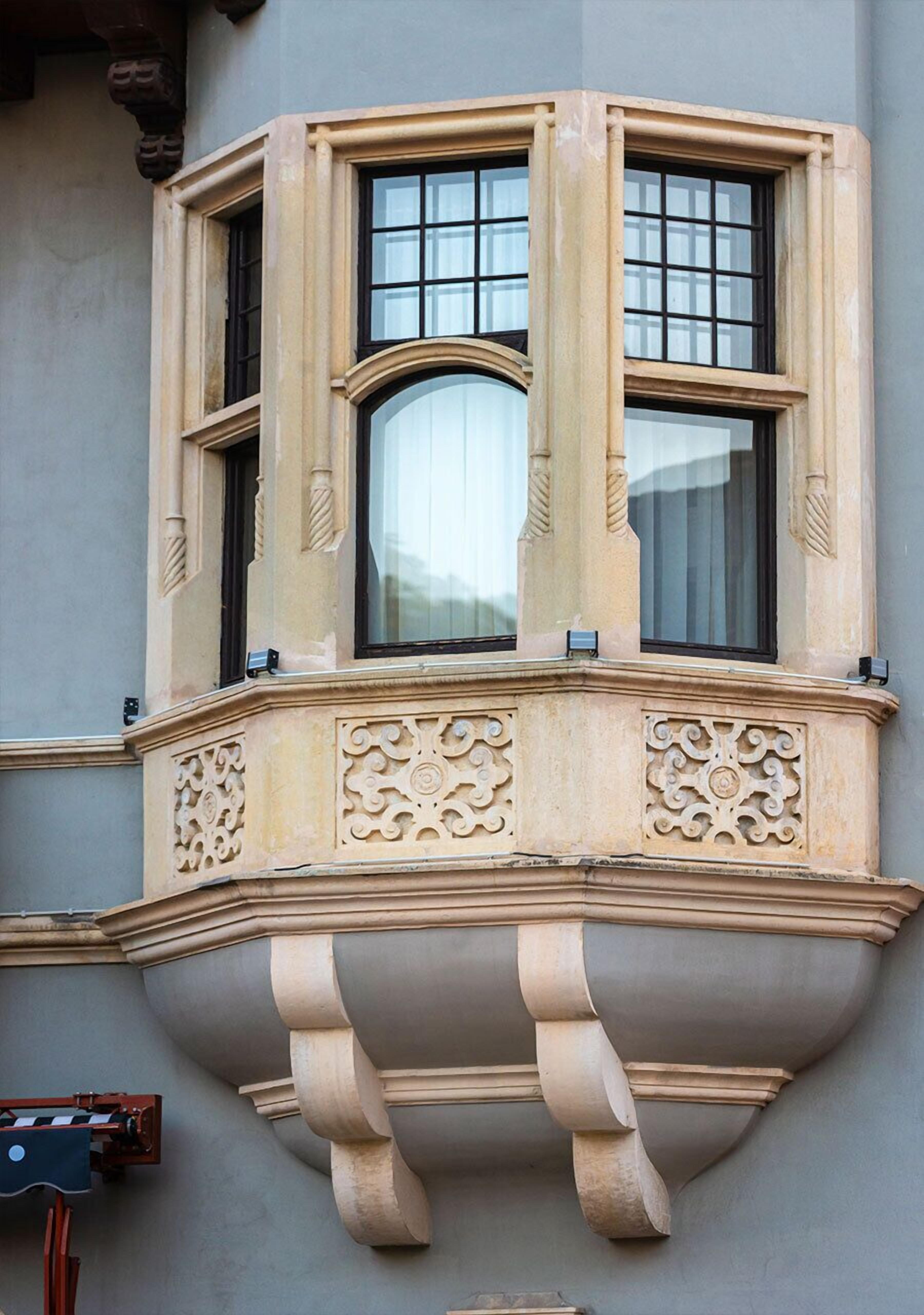 Una ventana de esquina con elaborados grabados y diseño curvo.