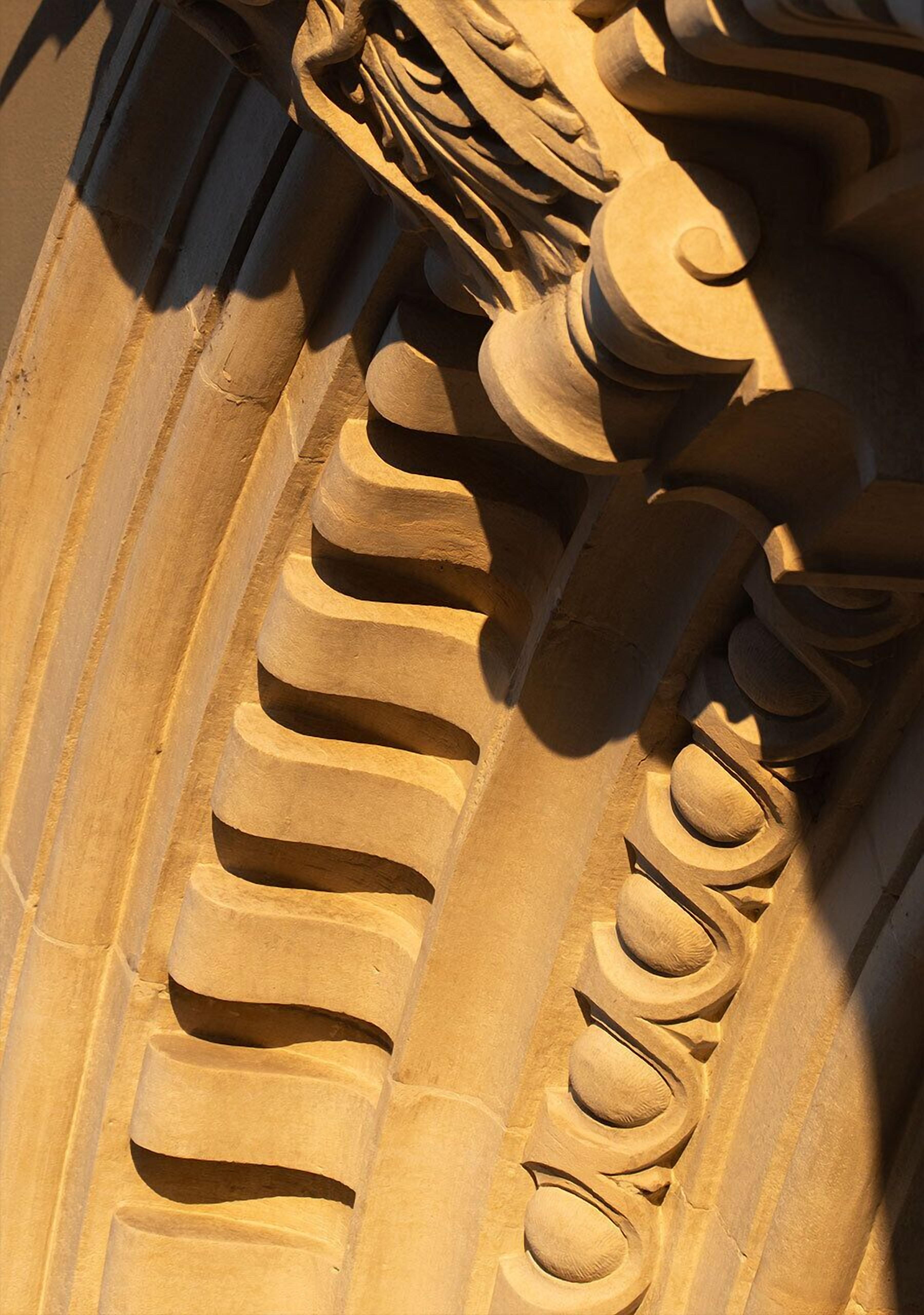A close-up of a stone architectural detail with carved patterns and grooves.