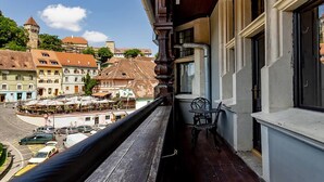 A balcony with a view of a town square, featuring buildings with traditional architecture and a tower. - Heritage Boutique Hotel Sighisoara (Sighişoara)