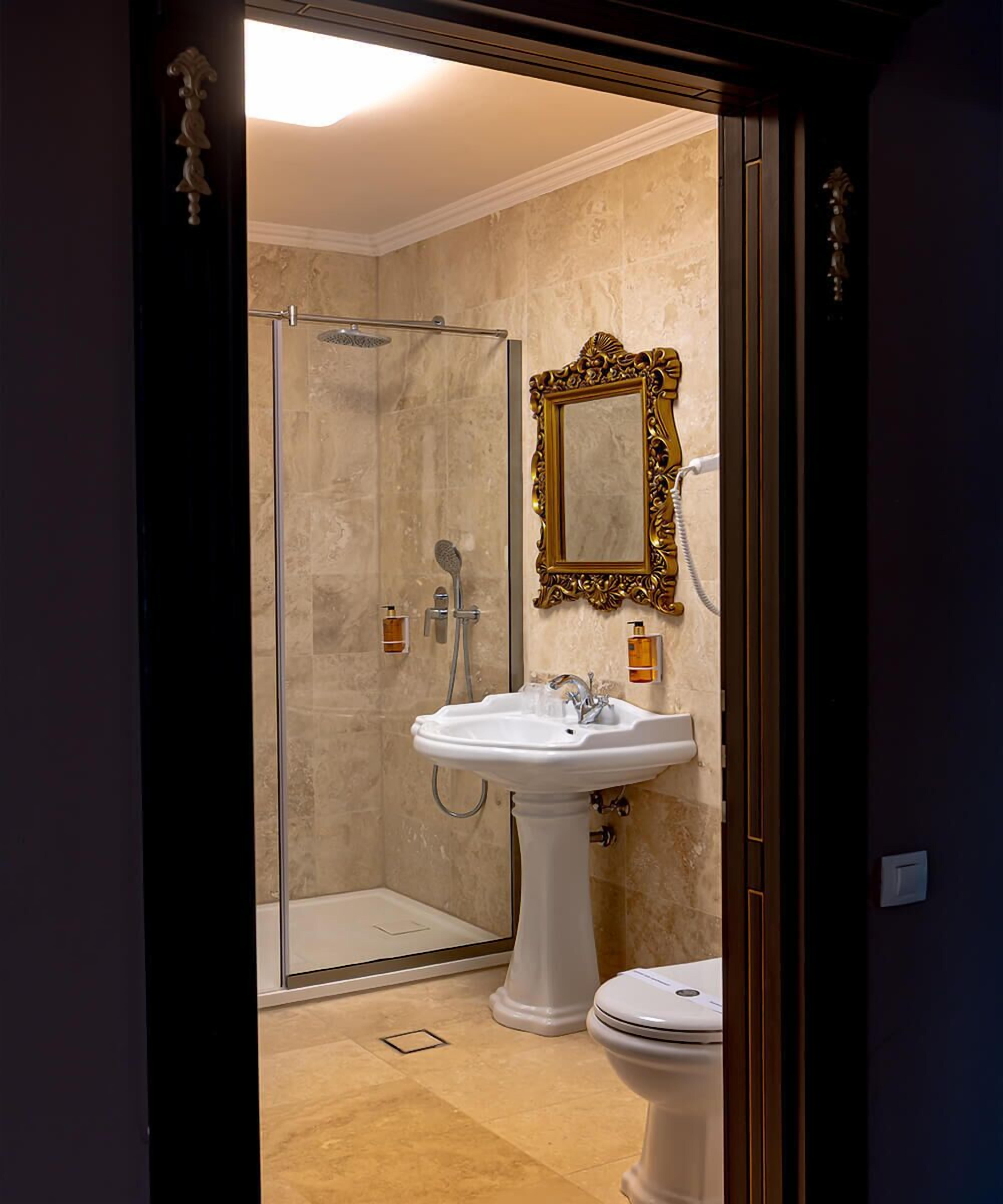 Ein Badezimmer mit Duschkabine, Standwaschbecken und Toilette.