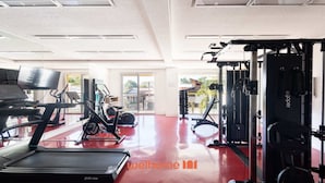 Et fitnesscenter med løbebånd, crosstrainere og vægttræningsudstyr.