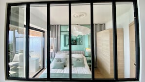 Un dormitorio moderno con una cama grande, vistas al balcón y un área de baño separada.