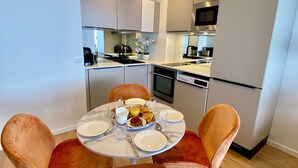 Una cocina moderna con armarios blancos, un microondas y un lavavajillas.