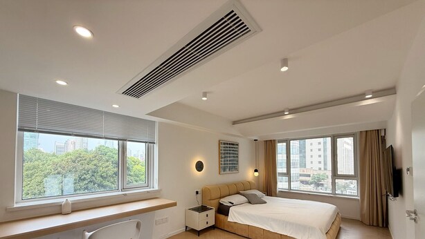 A modern bedroom with a bed, a desk, and a chair.