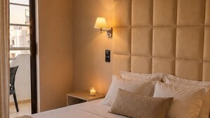 A hotel room with a large bed, a bedside table with a lamp, and a view of the outside balcony. - Rhodea Mar (Rhodes)