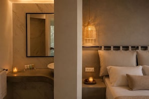 A modern bathroom with a marble sink, a mirror, and a bedside table with a candle. - Rhodea Mar (Rhodes)