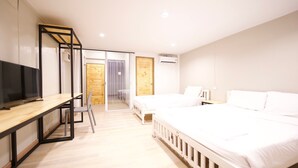 A modern hotel room with a wooden desk, a bed, and a TV. - Little Rooms (Chanthaburi)