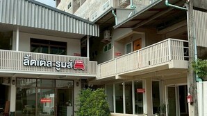 A two-story building with a sign reading "Anisa Suan" and balconies on the upper floor. - Little Rooms (Chanthaburi)