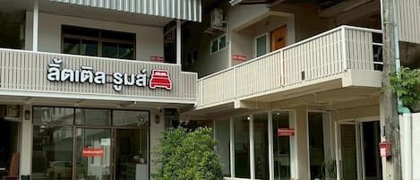Un edificio de dos pisos con un letrero que dice "Anisa Suan" y balcones en el piso superior.