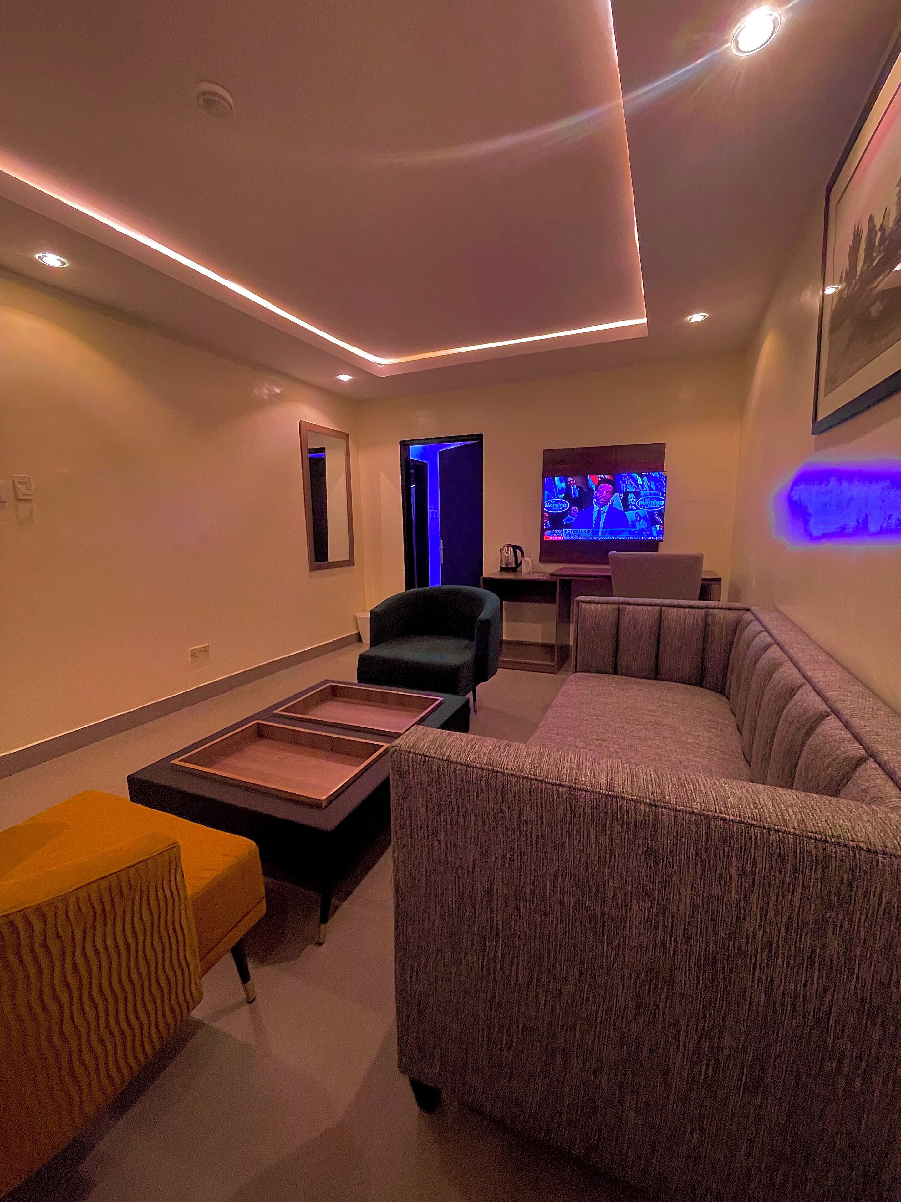 A modern living room with a sectional sofa, a small table, and a television.