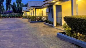 Ein modernes Hotel mit gepflasterter Auffahrt und gepflegter Bepflanzung.