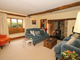 A cozy living room with a blue sofa, a wooden coffee table, and a stone fireplace.