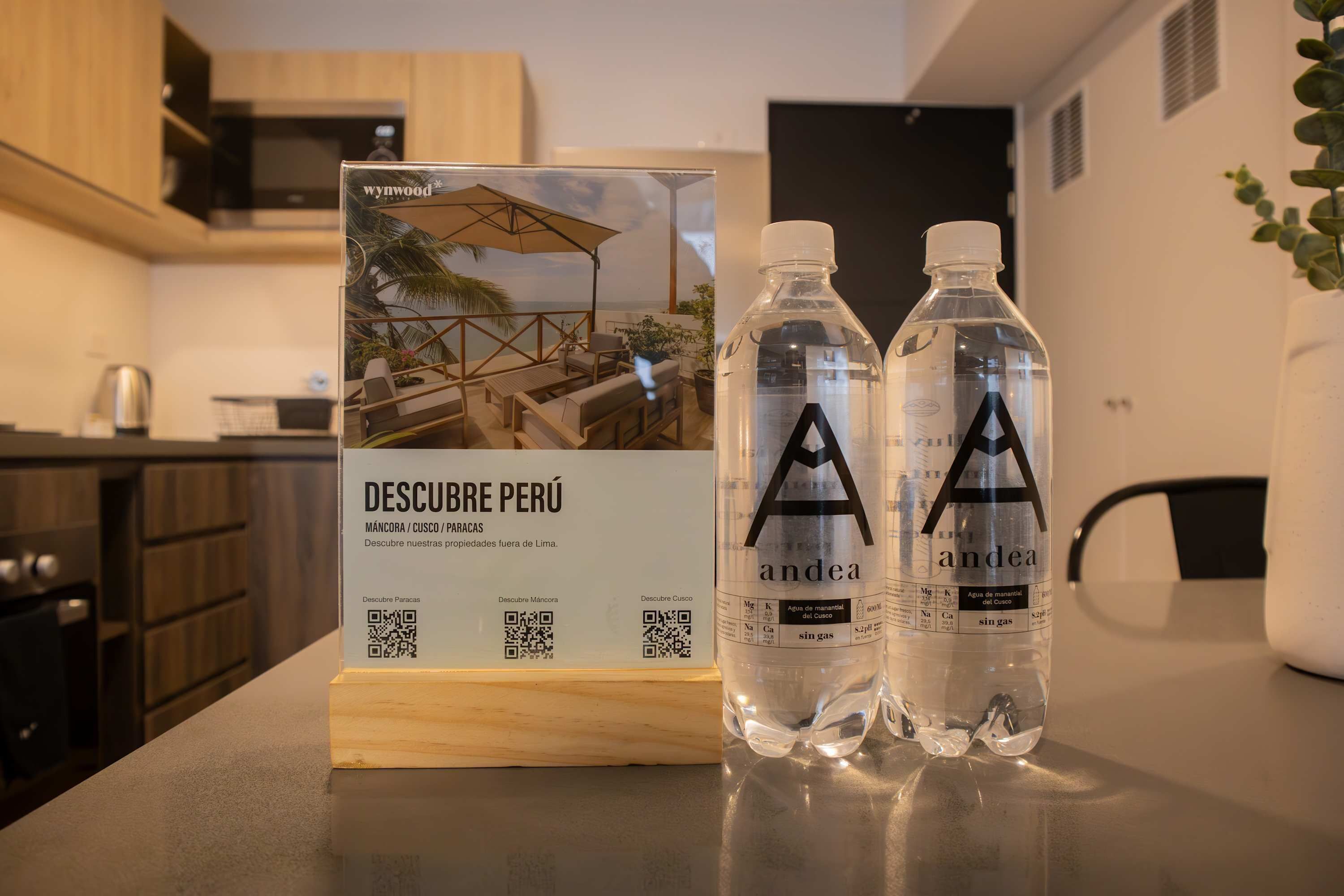 A kitchen counter with a sign for 'DESCUBRE PERÚ' and two water bottles labeled 'andea'.