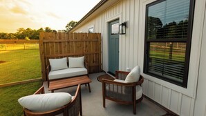 An outdoor patio with a wooden fence, a green door, and a large window. - Upscale Lodge Sleeps 9 Dog Friendly Near CU (Central)
