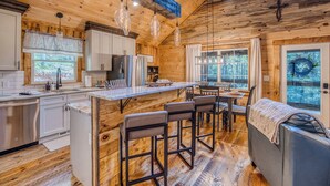 L’intérieur d’une cabane en rondins comprend une cuisine, un coin repas et un espace salon confortable.