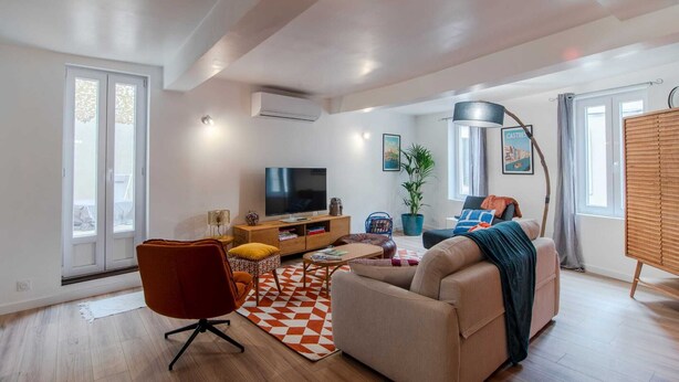 Ein modernes Wohnzimmer mit einer Couch, einem Fernseher und einem Couchtisch.