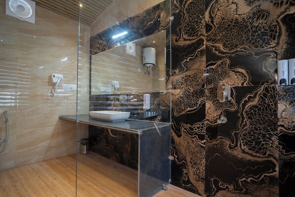 Une salle de bain moderne avec une paroi en verre, un lavabo et un miroir.