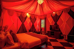 A room with a bed, a TV, a desk, and a chair. - Badi Garh Resort (Udaipur)