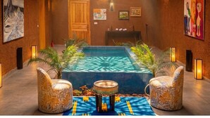 A spacious indoor area with a pool, seating, and artwork on the walls. - Bab Sma - Porte du Ciel (Tameslouht)