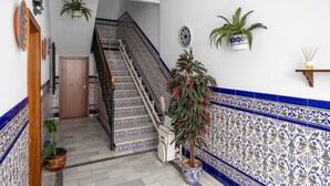 A staircase with blue and white patterned tiles, a wooden door, and potted plants. - \"marina house\" conil (Conil de la Frontera)