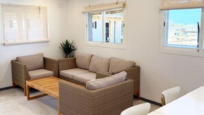 Una sala de estar moderna con un conjunto de sofá, una mesa de centro de madera y una mesa de comedor.