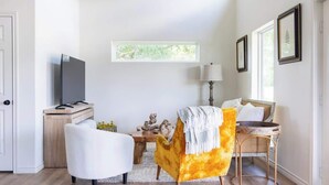A modern living room with a sofa, armchair, and a television on a stand. - 2 Bedrooms + Full Kitchen + 5 min drive to RT (Round Top)